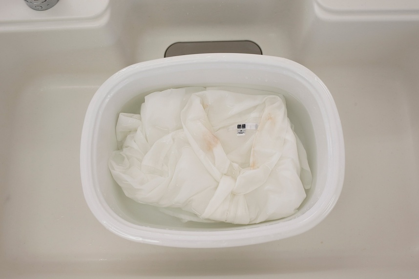 酸素の洗剤サンソリキの溶液に黄ばんだブラウスをつけ置くシーン